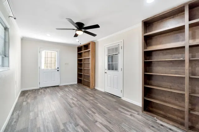 a view of empty room with wooden floor and window