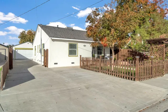 a view of a house with a wooden fence