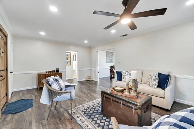 a living room with furniture and a wooden floor