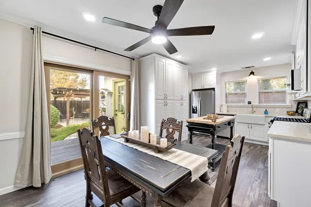 a dining room with furniture a chandelier and wooden floor
