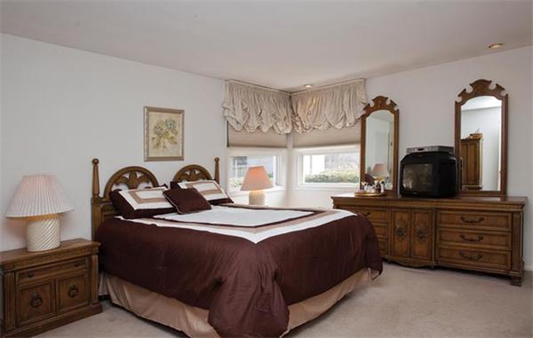 7 Grace Road Newton, MA 02459 - Photo 8 of 9 a bedroom with a bed and a flat tv screen on the dresser