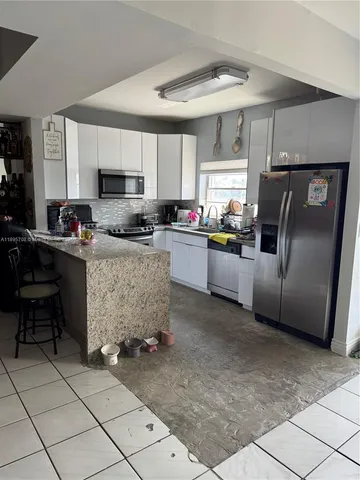 a kitchen with refrigerator and cabinets