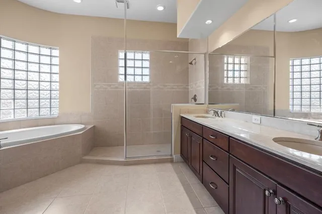 a spacious bathroom with a tub sink and glass door shower