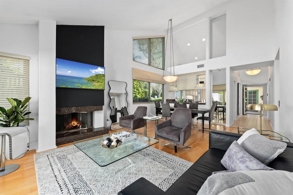 4074 Avenida Brisa Rancho Santa Fe, CA 92091 - Photo 6 of 32 a living room with furniture a fireplace a flat screen tv and a large window
