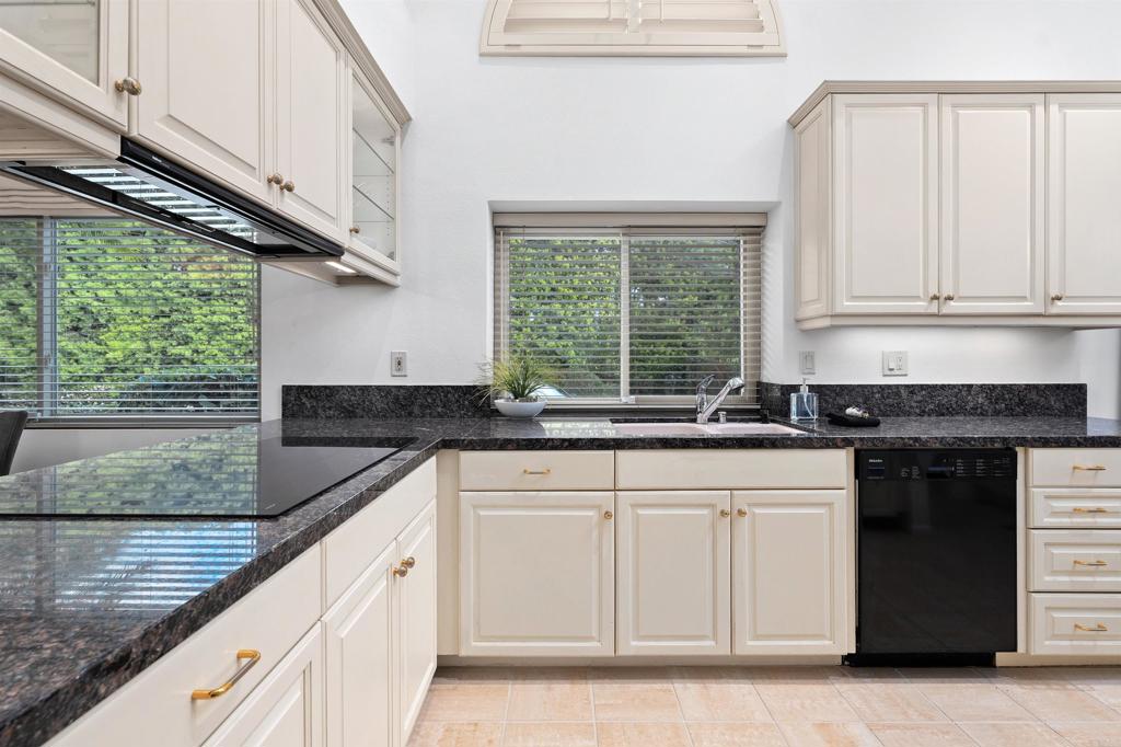 4074 Avenida Brisa Rancho Santa Fe, CA 92091 - Photo 10 of 32 a kitchen with granite countertop white cabinets and a window