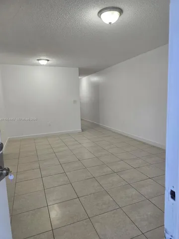 en empty room with white walls and tiles