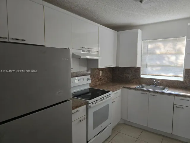 a kitchen with stainless steel appliances granite countertop white cabinets sink and dishwasher