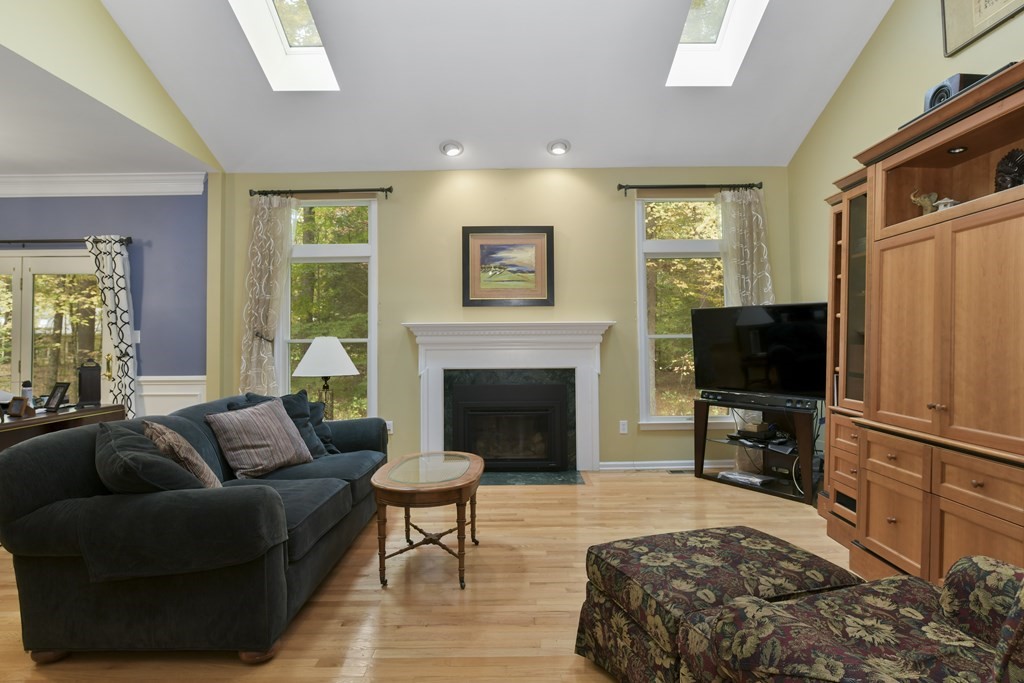 7 Moore Circle, Unit 7 Bedford, MA 01730 - Photo 8 of 27 a living room with furniture a flat screen tv and a fireplace