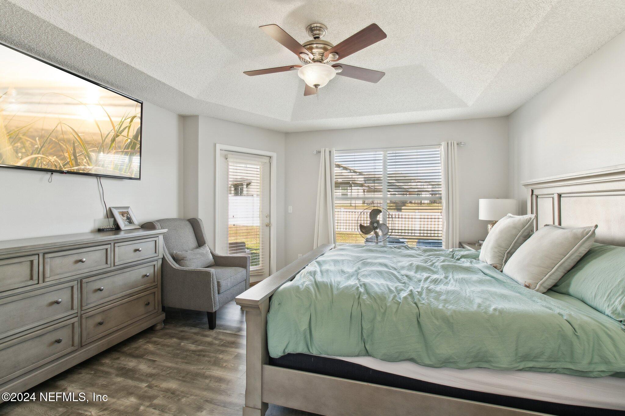 2955 Ravine Hill Drive Middleburg, FL 32068 - Photo 18 of 38 a bedroom with a large bed and a flat tv screen on dresser