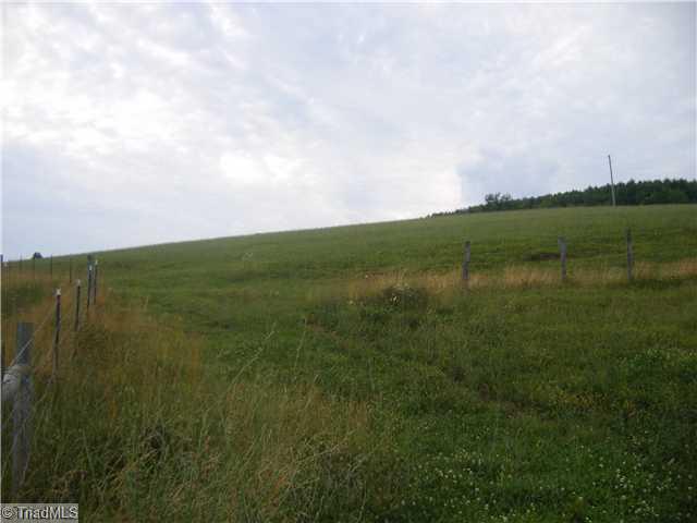 1583 Pleasant Home Road Sparta, NC 28675 - Photo 6 of 11 Exterior Front. View from junction of Duncan Ridge and Pleasant Home road looking up the pasture. Fence line is property line being sold.