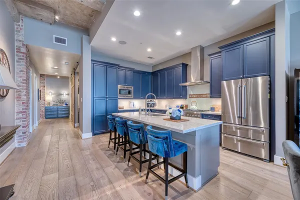 a kitchen with stainless steel appliances granite countertop wooden cabinets a center island and a refrigerator