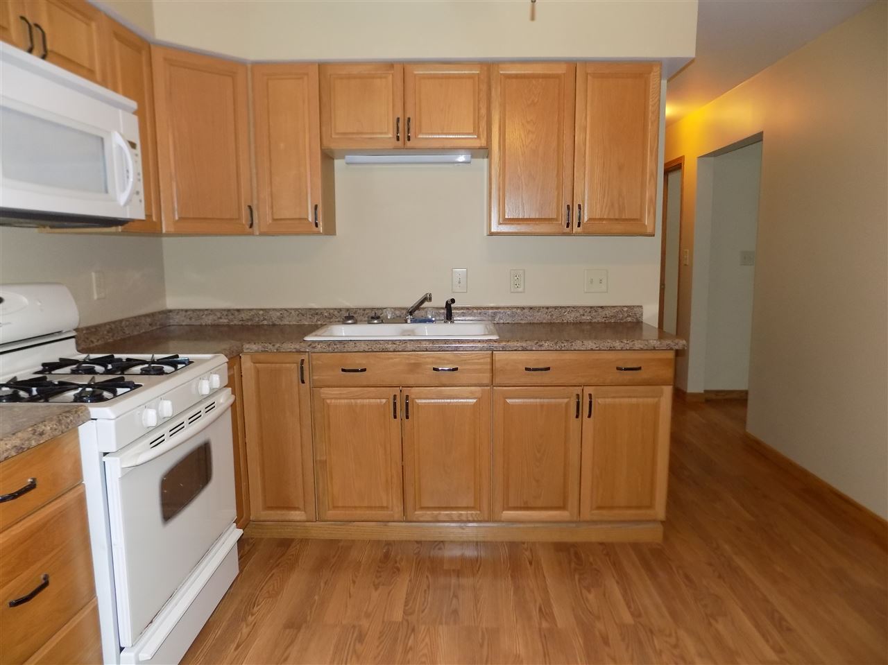 6201 Park Ridge Road Loves Park, IL 61111 - Photo 7 of 25 a kitchen with granite countertop a stove a sink and dishwasher with wooden floor