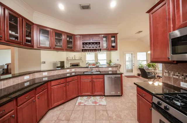 a kitchen with stainless steel appliances granite countertop stove top oven a sink dishwasher and cabinets with wooden floor