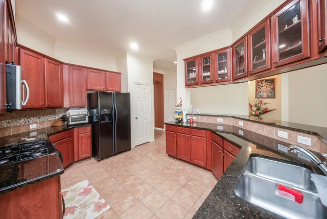 a kitchen with stainless steel appliances granite countertop a refrigerator and a stove top oven