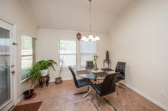 a dining room with furniture a chandelier and window