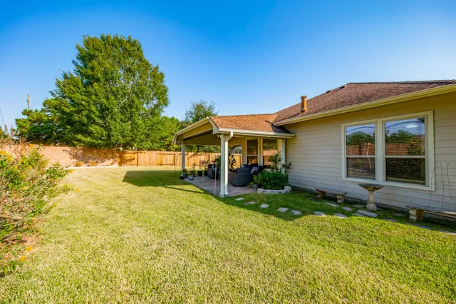 a view of house with backyard and glass windows