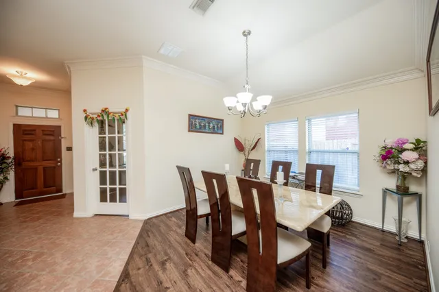 a view of a dining room with furniture wooden floor and chandelier