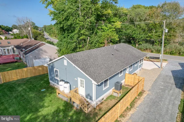 an aerial view of residential house with outdoor space and trees