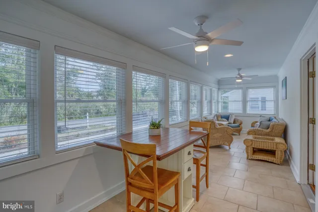 a dining room with furniture and a large window