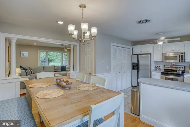 a large kitchen with sink a refrigerator and chairs