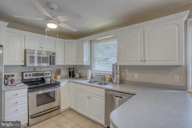 a kitchen with cabinets appliances a sink and a counter top space