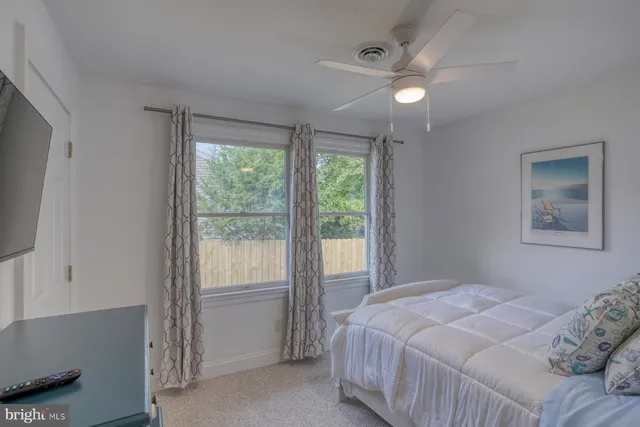 a bedroom with a large bed and a flat tv screen