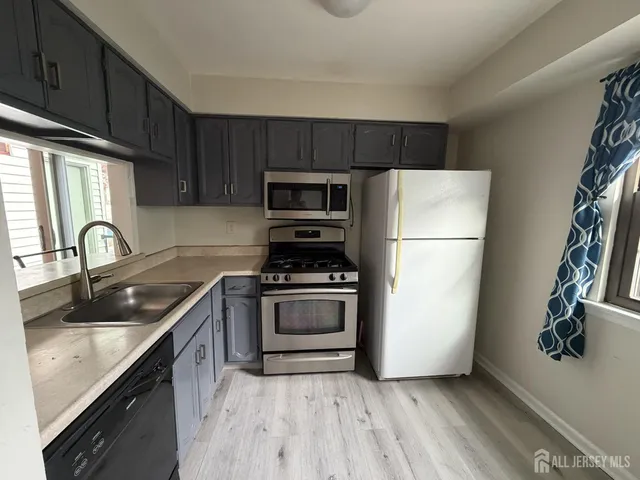 a kitchen with a refrigerator sink and wooden cabinets