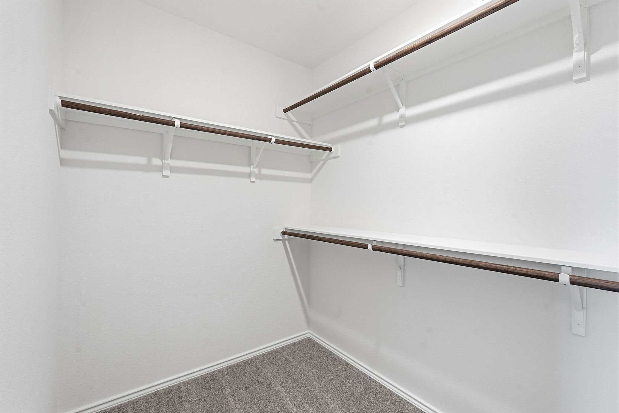 164 Cinnabar Lane, Unit 3 Kyle, TX 78640 - Photo 13 of 20 Spacious walk-in closet featuring white shelving with integrated hanging rods and gray carpet flooring