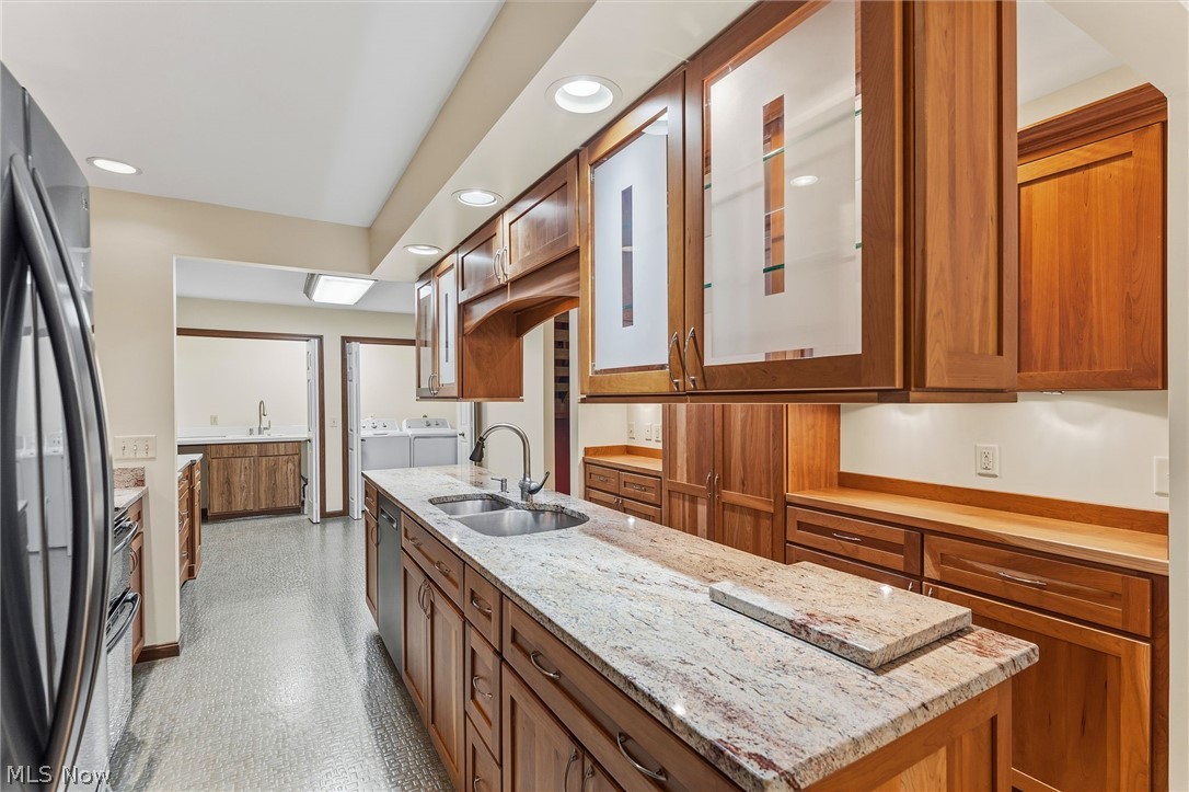 5741 Som Center Road, Unit 1 Solon, OH 44139 - Photo 18 of 50 Kitchen featuring a double basin sink, light-toned granite countertops, wood cabinetry with some glass-front uppers, and recessed lighting