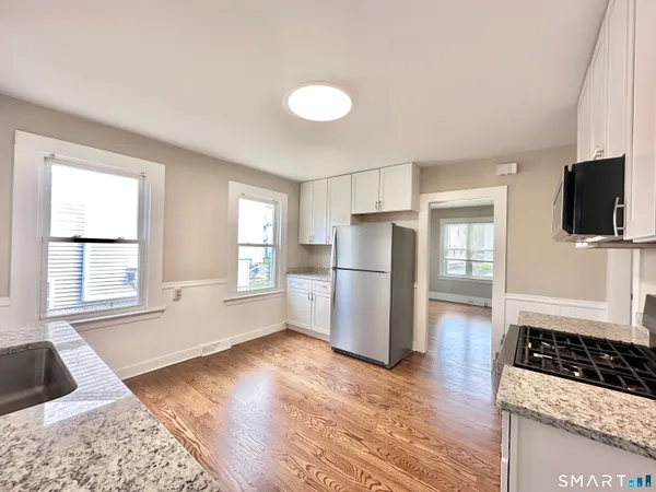 a kitchen with a refrigerator and a stove top oven