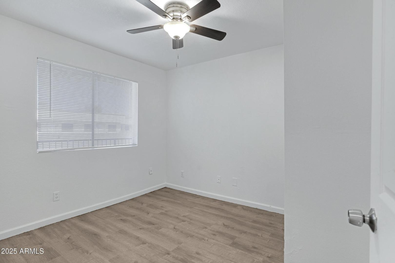 18202 North Cave Creek Road Phoenix, AZ 85032 - Photo 8 of 20 an empty room with a window and a fan