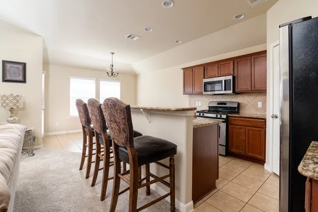 a kitchen with stainless steel appliances a refrigerator and a stove top oven