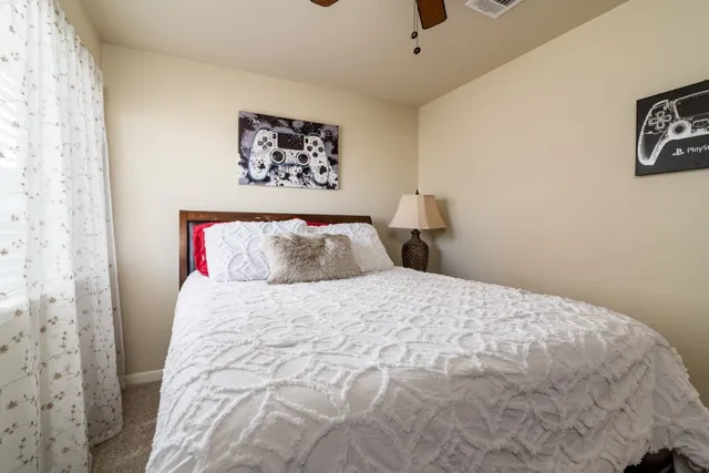 a bedroom with a bed and painting on the wall