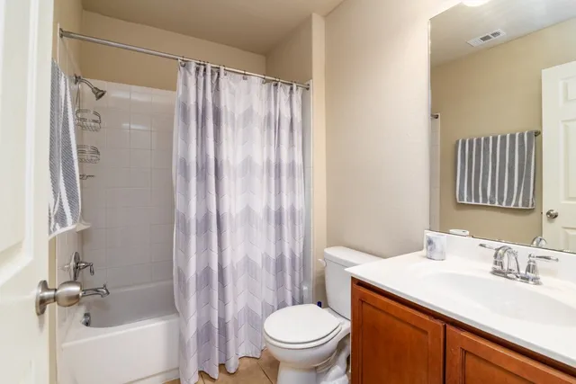 a bathroom with a sink a toilet and shower curtain