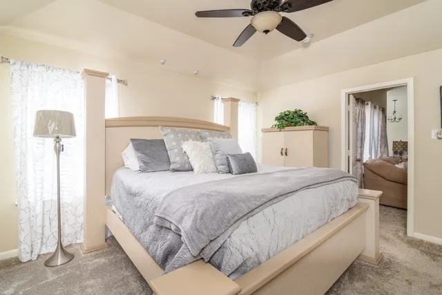 a bedroom with a large bed and ceiling fan