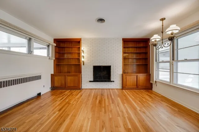 a view of an empty room with a fireplace and a window