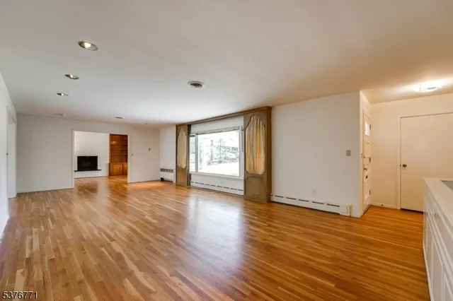 a view of empty room with wooden floor and window