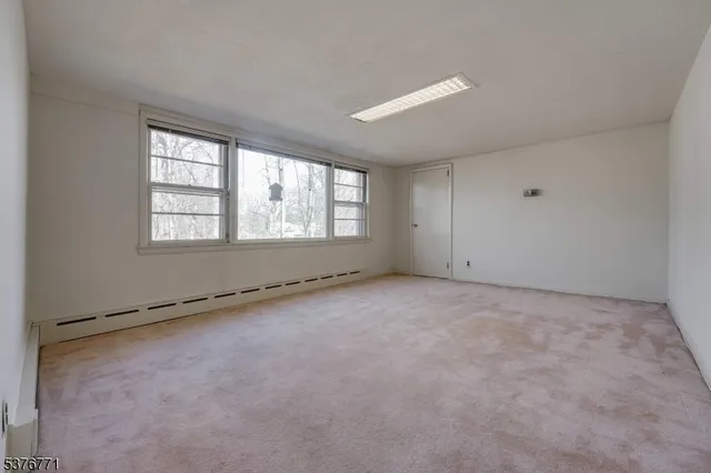 an empty room with a fireplace and windows