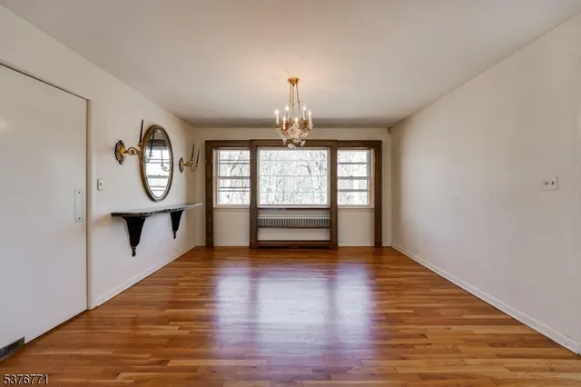 a view of an empty room window and wooden floor