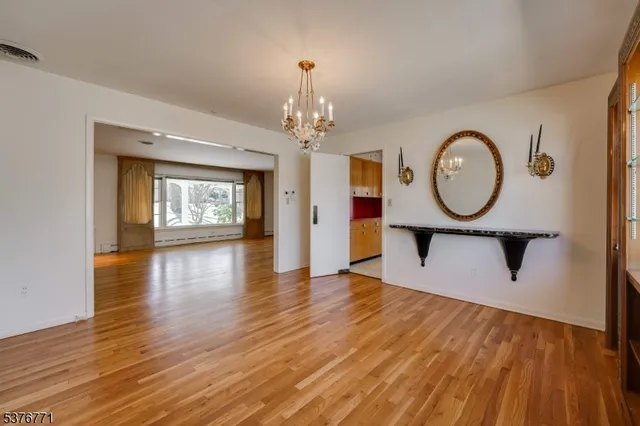 a view of a room with wooden floor window and a mirror
