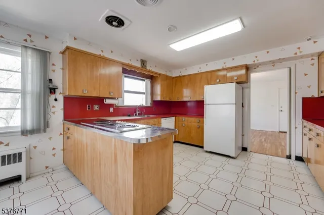 a kitchen with refrigerator a stove a sink a counter top space and cabinets