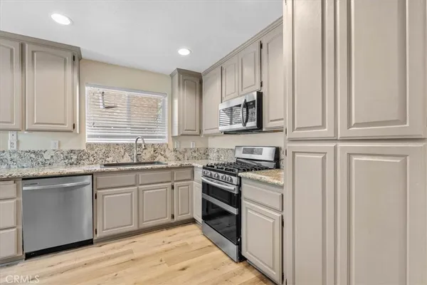 a kitchen with stainless steel appliances granite countertop a stove and a sink