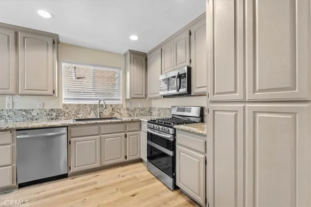 a kitchen with stainless steel appliances granite countertop a stove and a sink
