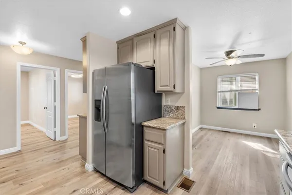 a kitchen with stainless steel appliances a refrigerator and wooden floor