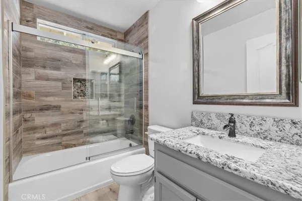 a bathroom with a granite countertop sink toilet and shower