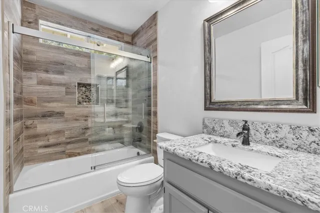 a bathroom with a granite countertop sink toilet and shower