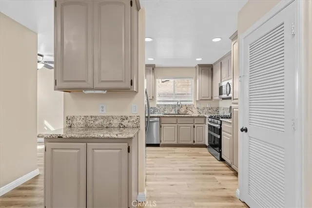 a kitchen with a refrigerator sink and cabinets