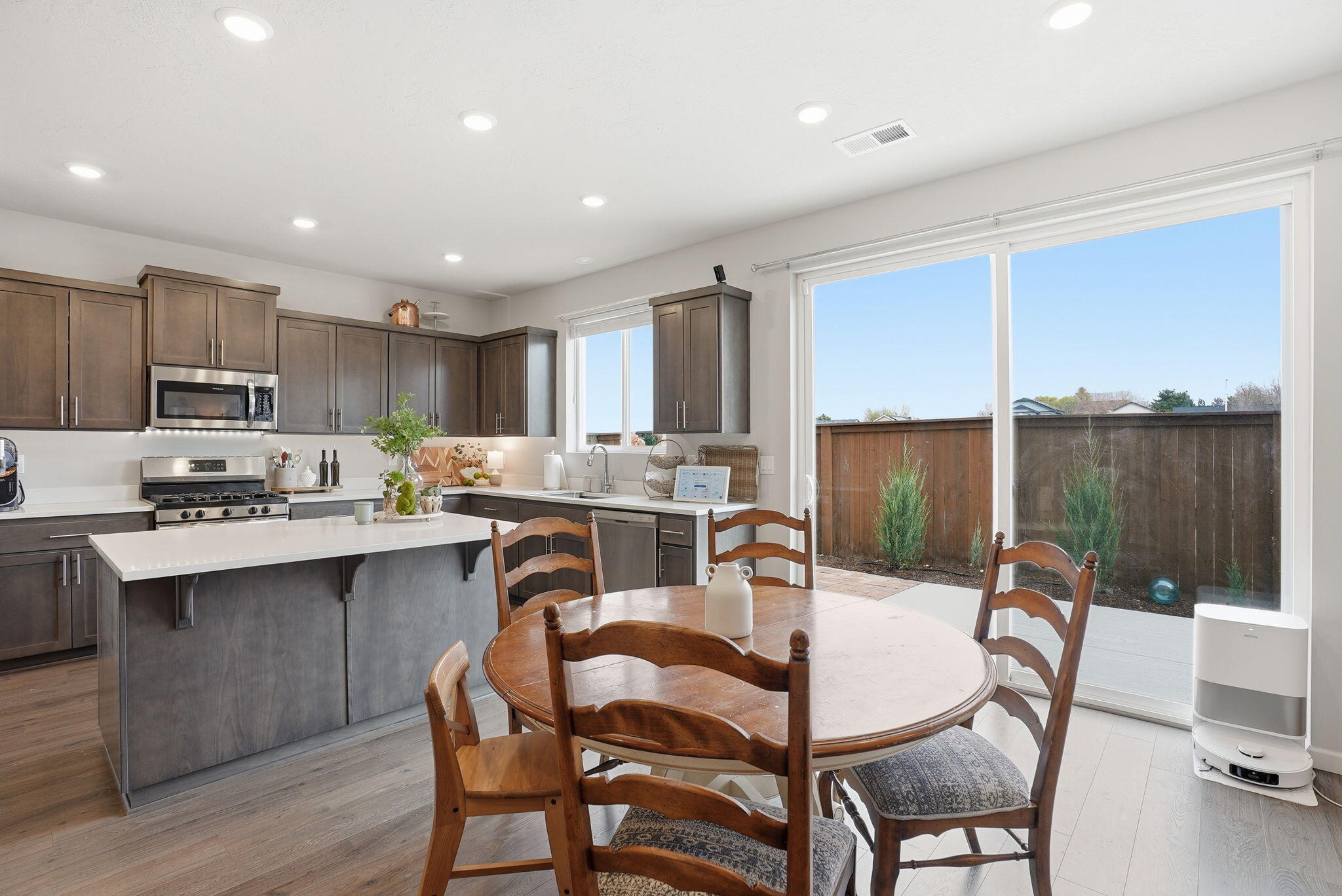 4015 Southwest Quartz Place Redmond, OR 97756 - Photo 9 of 35 a kitchen with kitchen island a dining table chairs and white cabinets