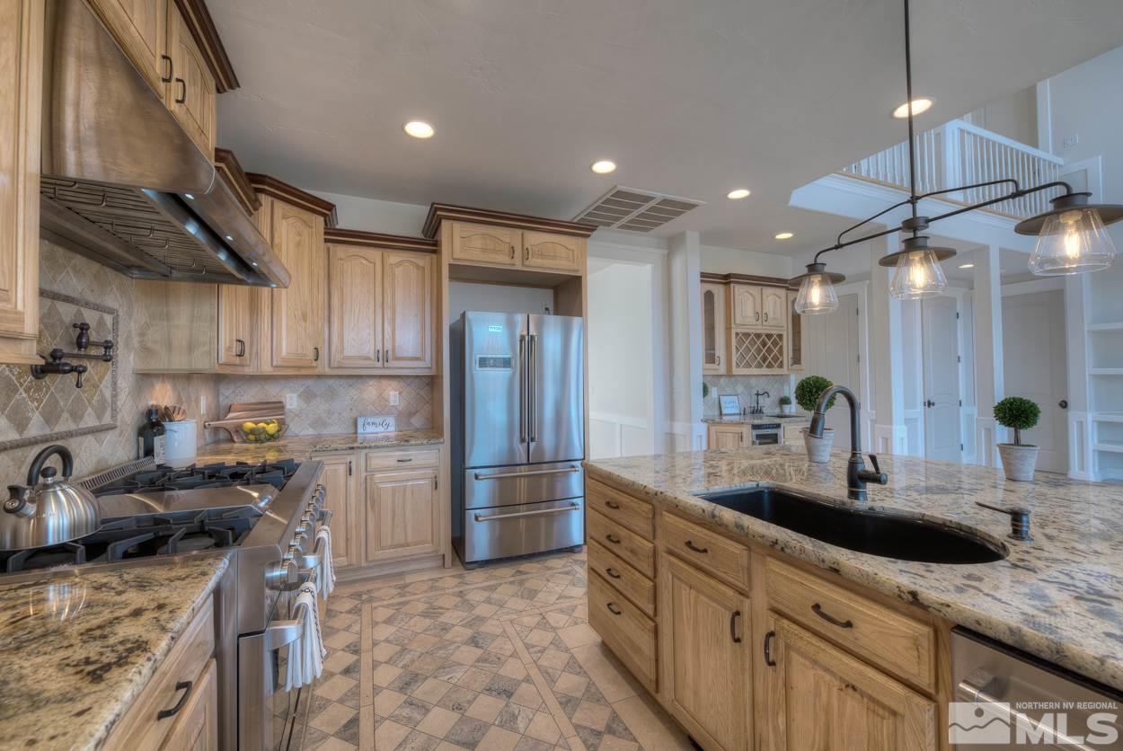 3220 Cartwright Road Reno, NV 89521 - Photo 5 of 25 a kitchen with stainless steel appliances granite countertop a sink a stove and a refrigerator