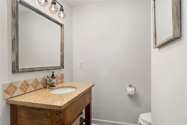 a kitchen with kitchen island granite countertop a sink a center island stainless steel appliances and cabinets